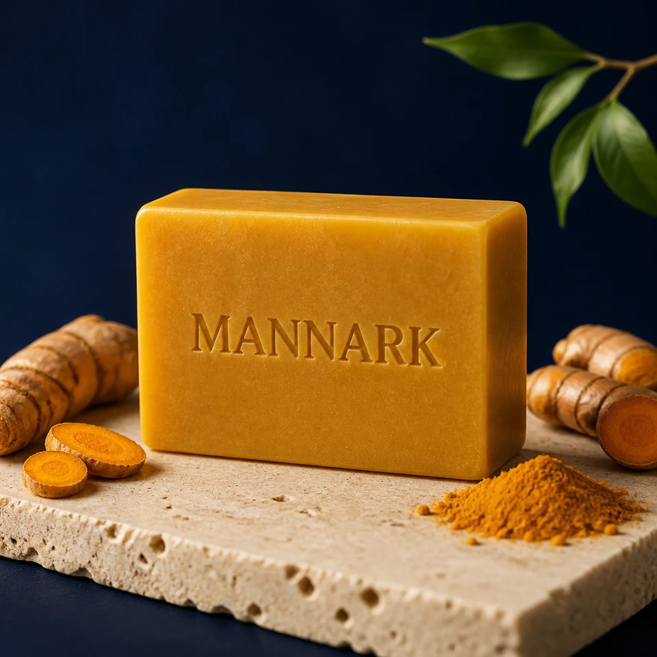 MANNARK Turmeric Glow Soap on stone with fresh turmeric roots and powder